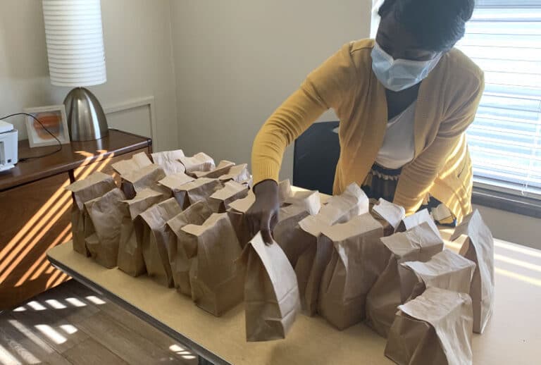Woman folding brown bag lunches
